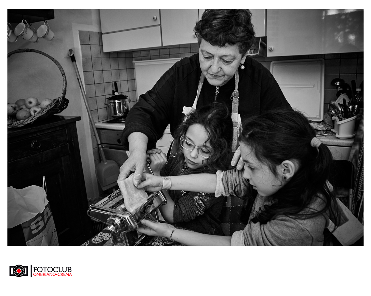 Nonna e nipoti intenti a lavorare insieme alla tradizione della pasta fatta in casa